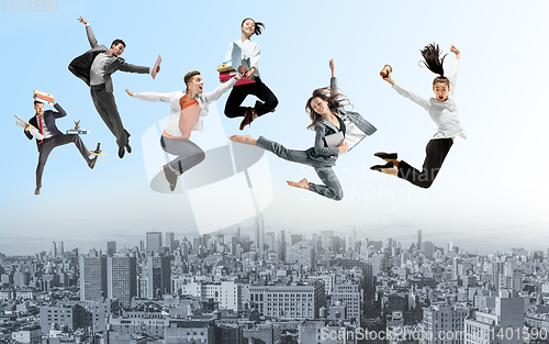 Image of Office workers or ballet dancers jumping above the city