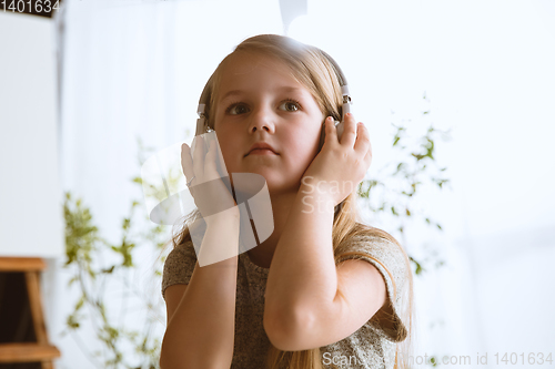 Image of Little girl using different gadgets at home