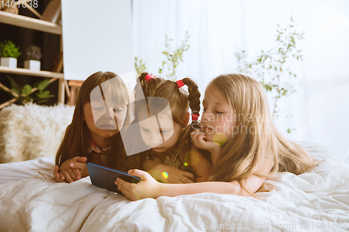 Image of Little girls using different gadgets at home