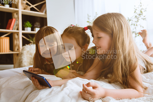 Image of Little girls using different gadgets at home