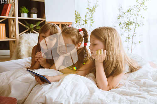 Image of Little girls using different gadgets at home