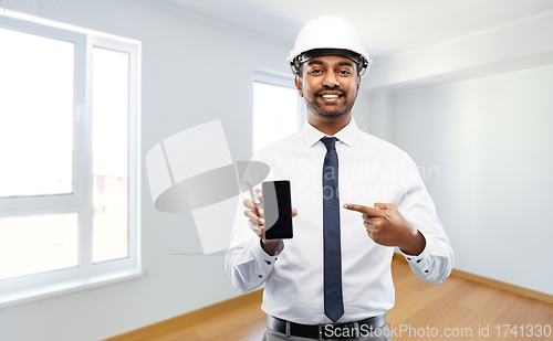 Image of indian male architect in helmet showing smartphone