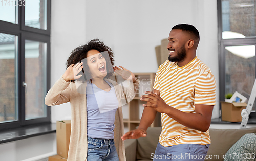 Image of happy couple moving to new home and dancing