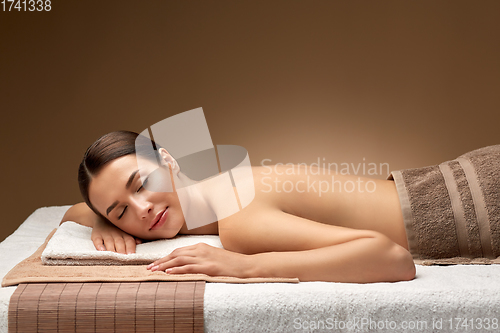 Image of young woman lying at spa or massage parlor