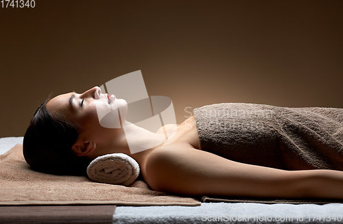 Image of young woman lying at spa or massage parlor