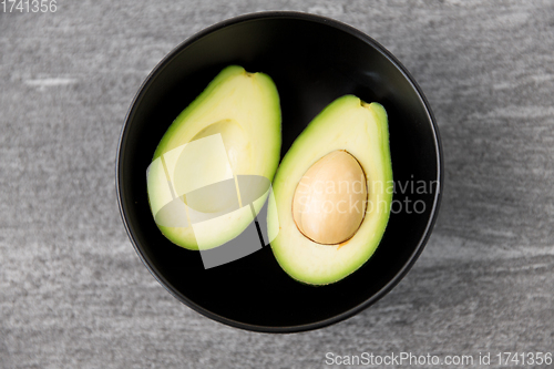 Image of close up of ripe avocado with bone in ceramic bowl