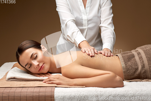 Image of woman lying and having back massage at spa