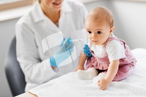 Image of doctor making vaccine for baby patient at clinic