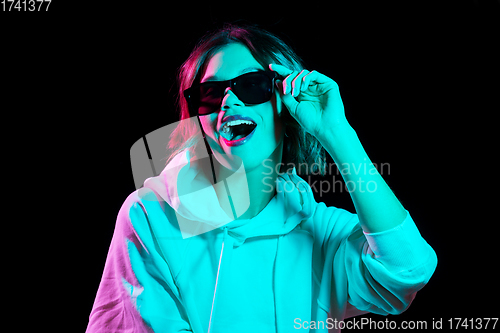 Image of woman wearing hoodie in neon lights over black