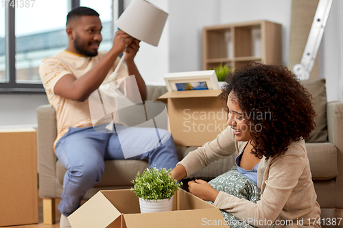 Image of happy couple packing boxes and moving to new home