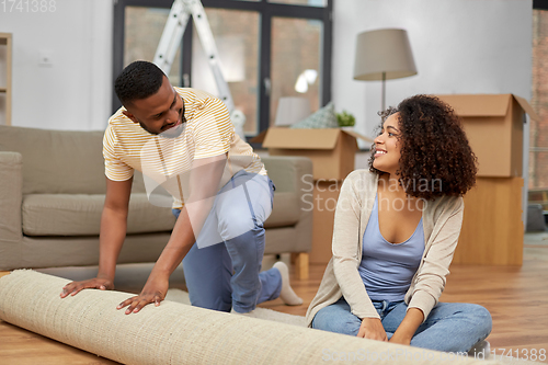 Image of happy couple with carpet moving to new home