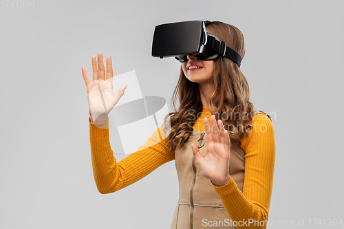 Image of teenage girl in vr glasses over grey background