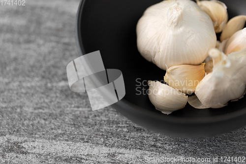 Image of garlic in bowl on slate stone background