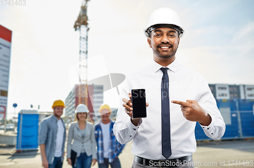 Image of architect showing smartphone at construction site