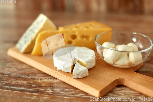 Image of different kinds of cheese on wooden cutting board