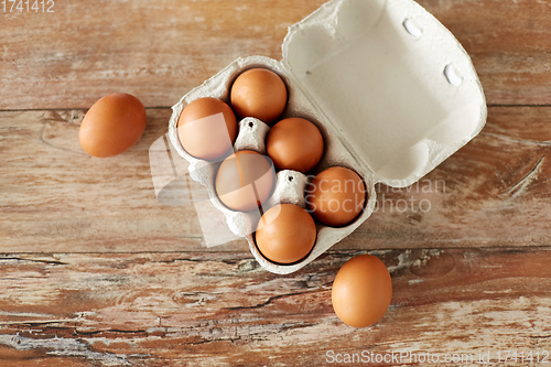 Image of close up of eggs in cardboard box on wooden table