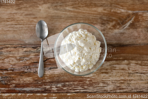 Image of close up of cottage cheese in bowl on wooden table