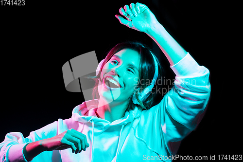 Image of woman in headphones listening to music and dancing