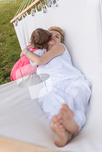 Image of mother and a little daughter relaxing in a hammock