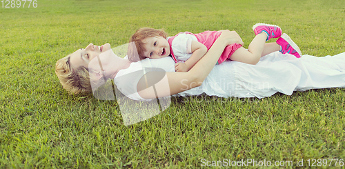 Image of mother and little daughter playing at backyard