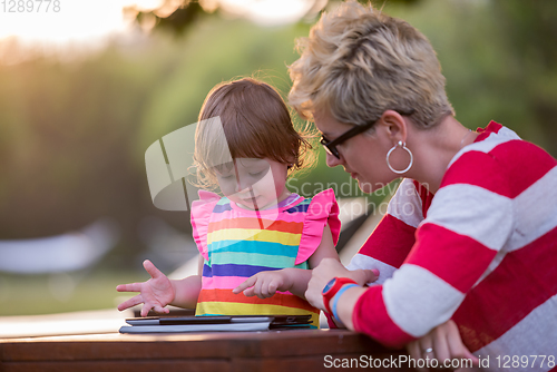 Image of mom and her little daughter using tablet computer