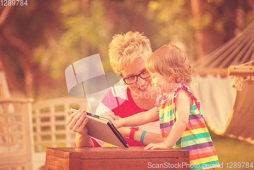 Image of mom and her little daughter using tablet computer
