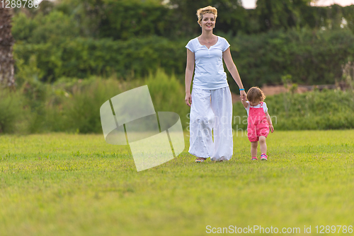 Image of mother and little daughter playing at backyard