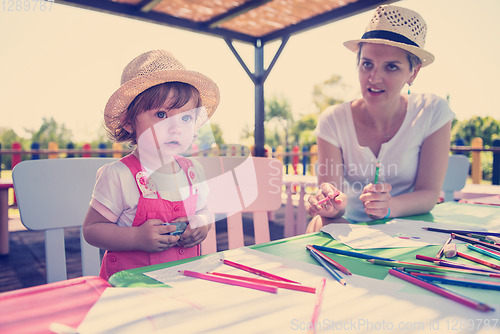 Image of mom and little daughter drawing a colorful pictures