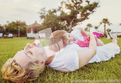 Image of mother and little daughter playing at backyard