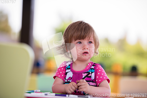 Image of little girl drawing a colorful pictures