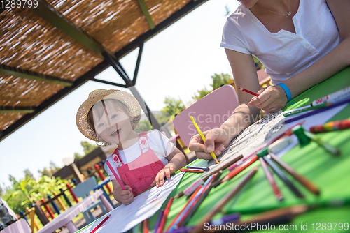 Image of mom and little daughter drawing a colorful pictures