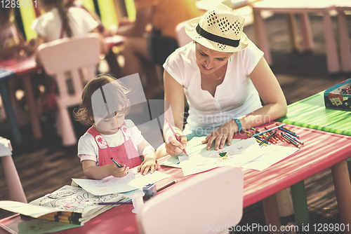 Image of mom and little daughter drawing a colorful pictures