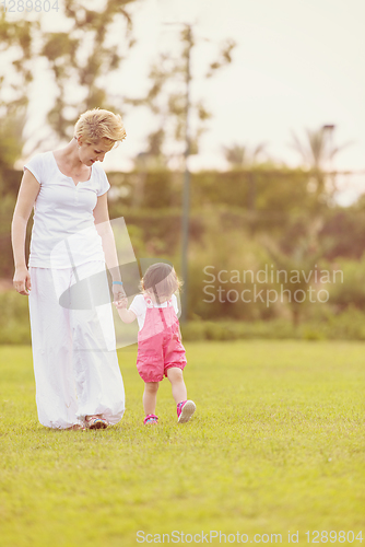 Image of mother and little daughter playing at backyard