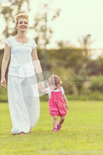 Image of mother and little daughter playing at backyard