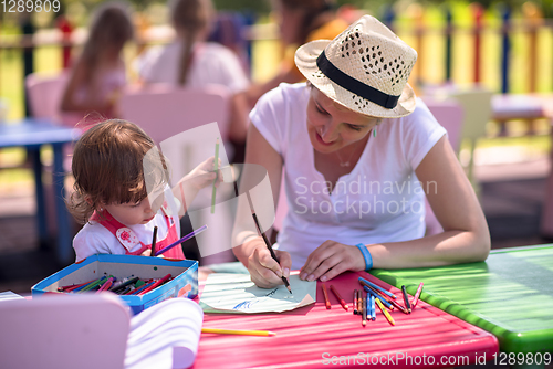 Image of mom and little daughter drawing a colorful pictures