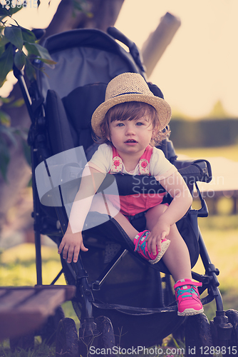 Image of baby girl sitting in the baby stroller