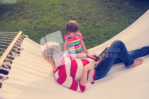 Image of mom and a little daughter relaxing in a hammock