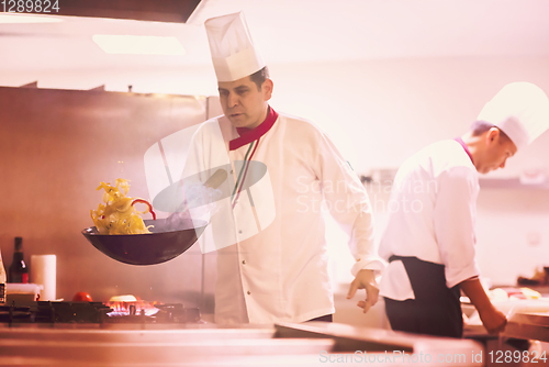 Image of chef flipping vegetables in wok