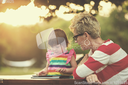 Image of mom and her little daughter using tablet computer