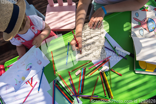 Image of mom and little daughter drawing a colorful pictures