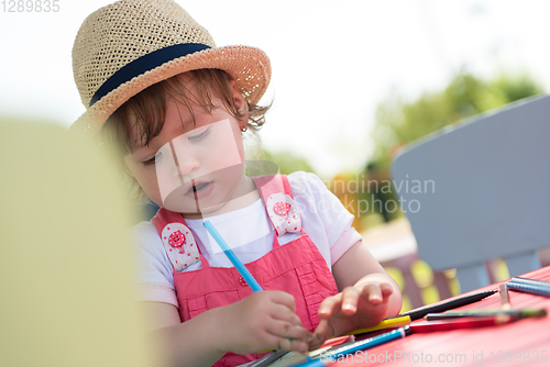 Image of little girl drawing a colorful pictures