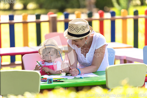 Image of mom and little daughter drawing a colorful pictures