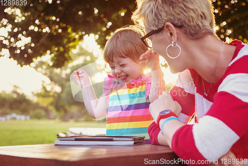 Image of mom and her little daughter using tablet computer