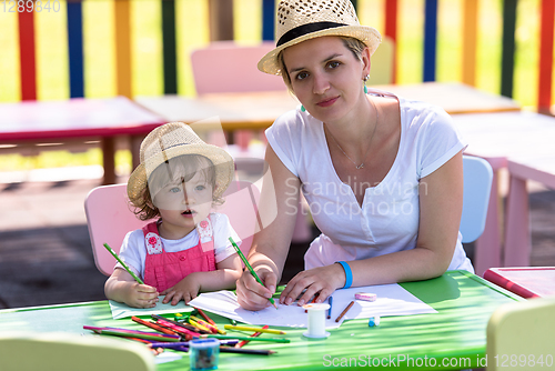 Image of mom and little daughter drawing a colorful pictures