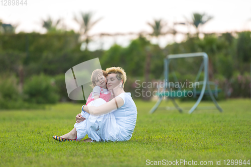 Image of mother and little daughter playing at backyard