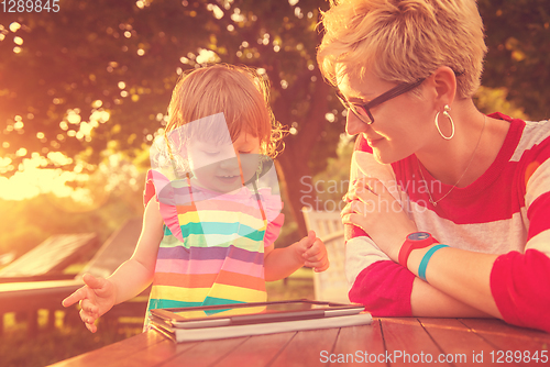 Image of mom and her little daughter using tablet computer