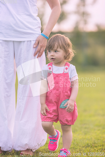 Image of mother and little daughter playing at backyard