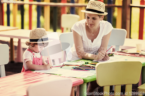 Image of mom and little daughter drawing a colorful pictures