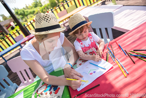 Image of mom and little daughter drawing a colorful pictures