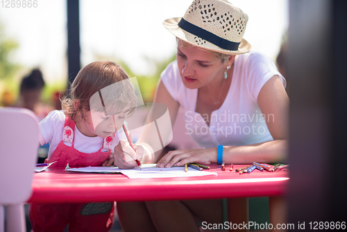 Image of mom and little daughter drawing a colorful pictures